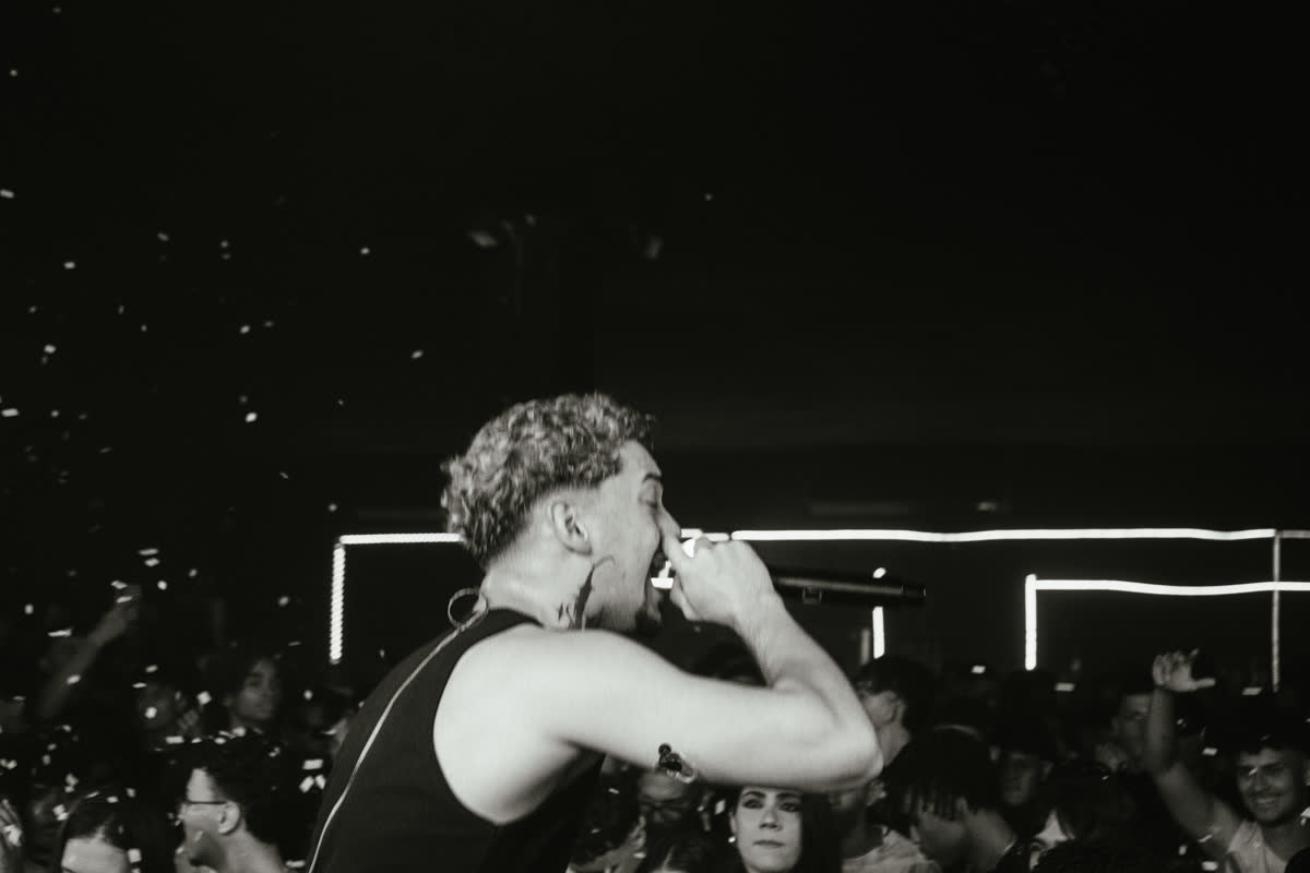 Show em preto e branco com a plateia e o letreiro ao fundo
